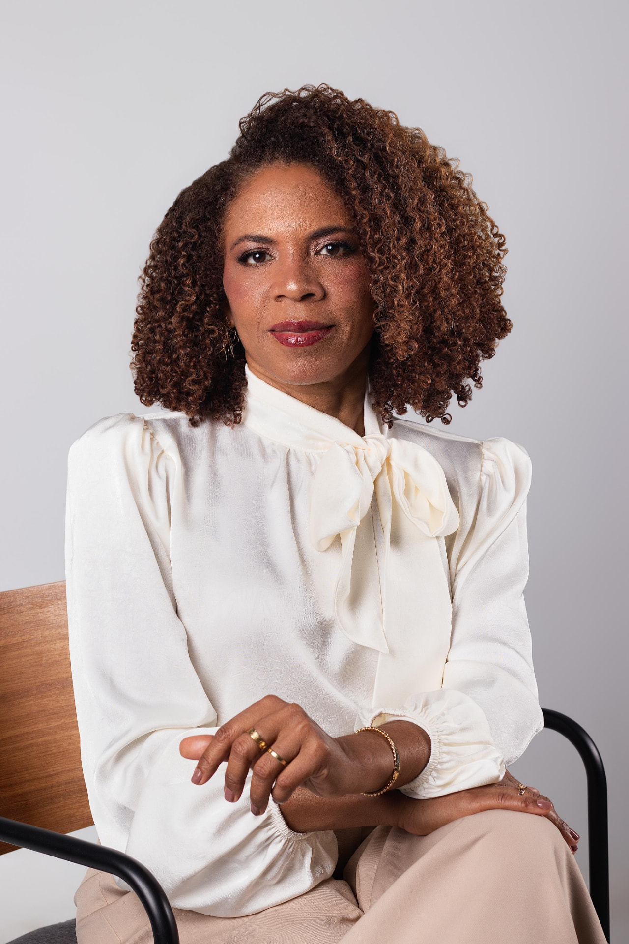 Dra. Cláudia Rodrigues sentada, com camisa branca
